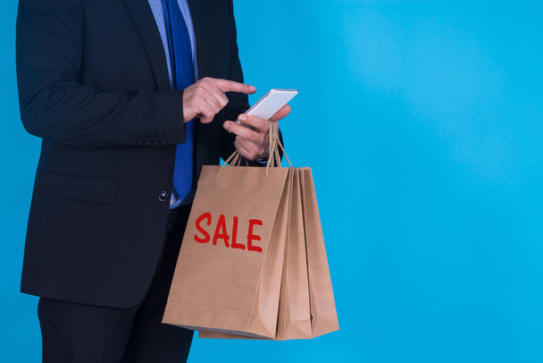 businessman with cardboard bag and mobile phone, online shopping concept - Fotó, kép