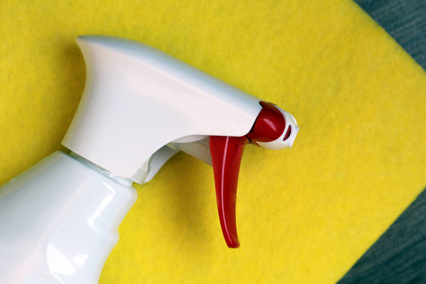 Une bouteille de spray nettoyant pour vitres si près d'un chiffon jaune - Photo, image
