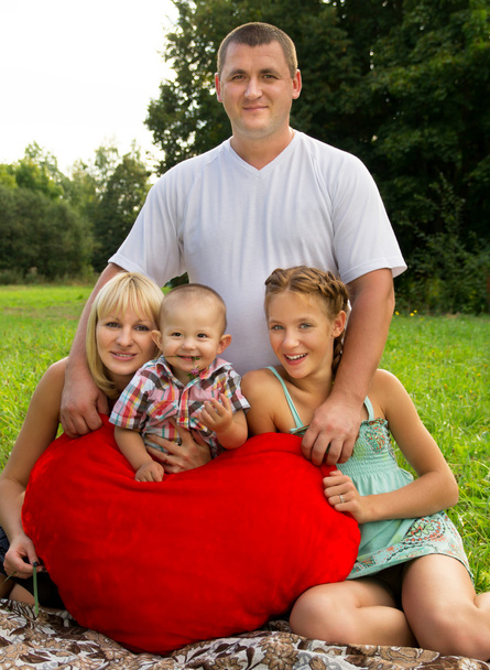 parents avec des enfants couchés sur l'herbe et tenant un cœur
 - Photo, image