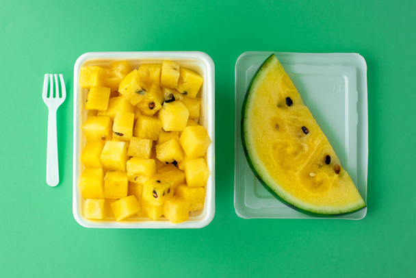 ripe yellow watermelon cut into pieces in a plastic white bowl - Foto, immagini