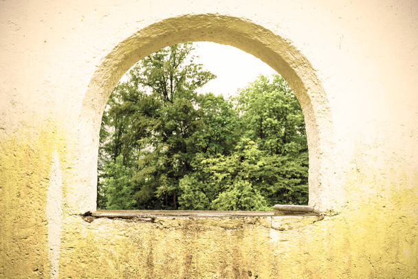 Nature view the Austrian village St Wolfgang through the arched window in the wall. Retro style - Photo, Image