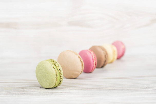 A closeup shot of colorful macaroons on wooden table - Photo, image