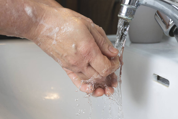 Gros plan d'un homme se lavant les mains avec un savon mousseux COVID-19, concept de coronavirus - Photo, image