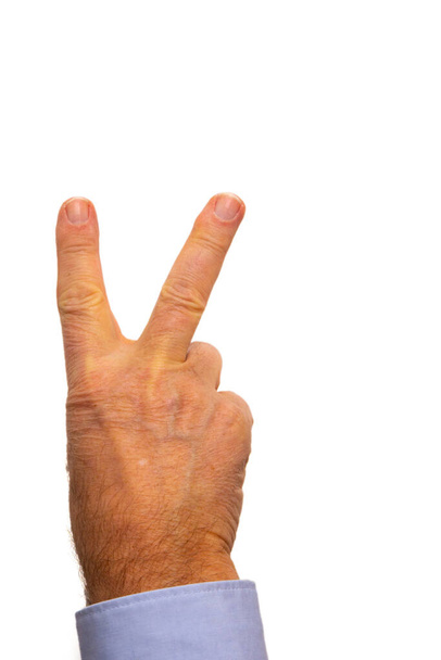 An isolated shot of a human hand with fingers showing the victory sign in front of a white background - Foto, immagini