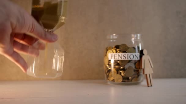Man turning hourglass on table. Concept of pension - Footage, Video