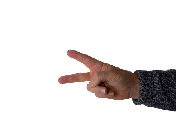 An isolated shot of a human hand with fingers showing the victory sign in front of a white background - Fotó, kép