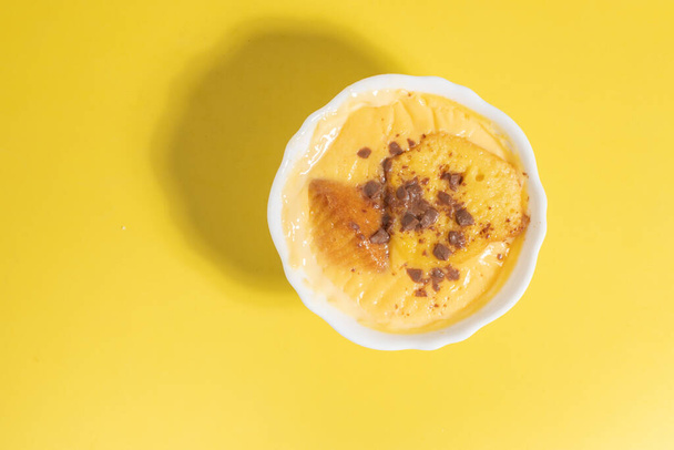A top view of delicious custard with cinnamon in a bowl on a yellow background - Foto, Imagem