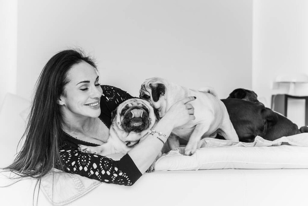 Nice woman with cute pug dog at home. Pet adoption, life of pets. Female carrying a pug, animals healthy happy canine adorable breed - Photo, Image