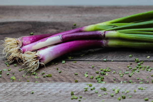A closeup shot of fresh spring onions on a wooden surface - Foto, immagini
