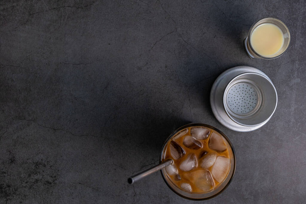 An overhead shot of Vietnamese iced coffee, condensed milk  and Vietnamese coffee filter with space for your text - Fotografie, Obrázek