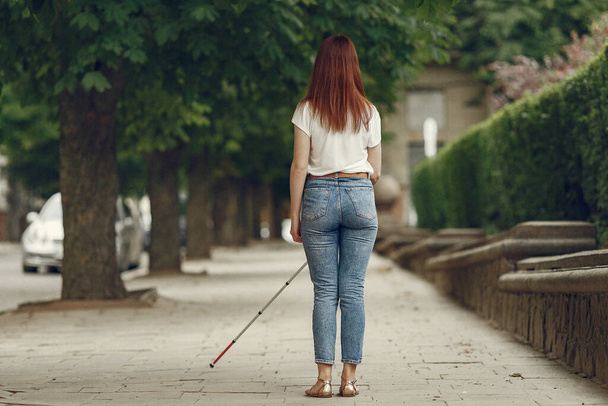 Young blind person with long cane walking in a city - Photo, image