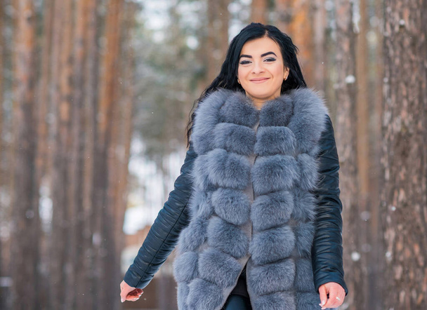 Femme en manteau de fourrure gris marcher en forêt le jour d'hiver à l'extérieur, dames mode décontractée - Photo, image