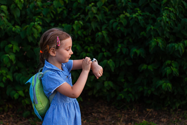 Παιδί που χρησιμοποιεί SmartWatch εξωτερική στο πάρκο. Το παιδί μιλάει στο βίντεο κλιπ στο smartphone. Μαθήτρια που χρησιμοποιεί οθόνη αφής σε ρολόγια περιήγηση στο διαδίκτυο. Έξυπνο ρολόι χειρός με GPS tracker. - Φωτογραφία, εικόνα