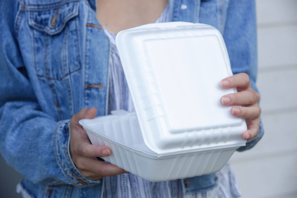 Les mains de femme tenant des boîtes à lunch en mousse à emporter. Contenants alimentaires à usage unique, gros plan. - Photo, image