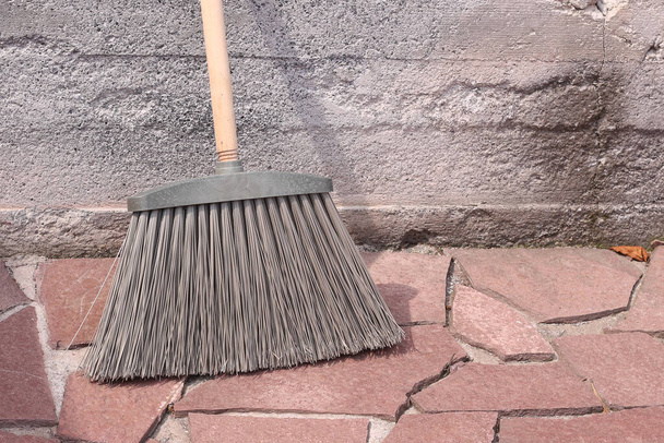 broom with hard plastic bristles on a stone surface. - Fotó, kép