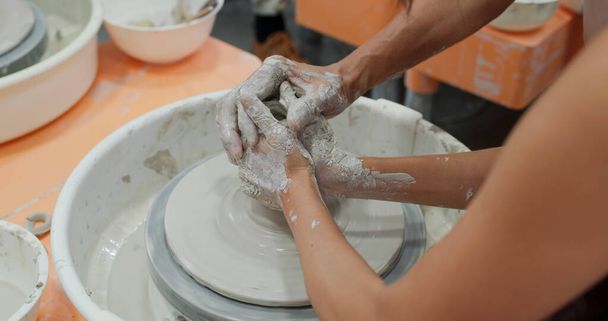 Töpfer macht Keramiktopf auf der Töpferscheibe  - Foto, Bild