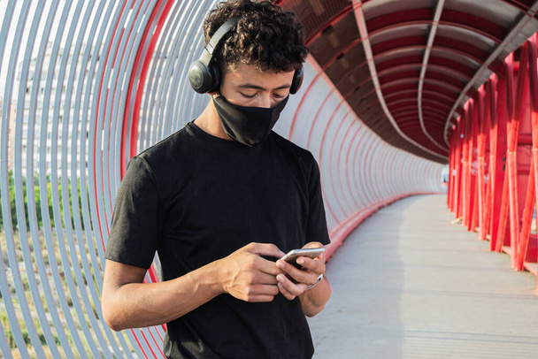 Fiatal férfi kezében az okostelefon előtt futni  - Fotó, kép
