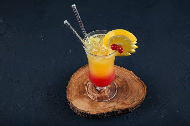 Juicy Orange και Red Tequila Sunrise με κεράσι. Tequila sunrise κοκτέιλ σε σκούρο ξύλινο τραπέζι. - Φωτογραφία, εικόνα