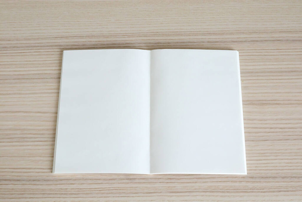 Mock up leeres aufgeschlagenes Papierbuch auf Holz Tischhintergrund - Foto, Bild