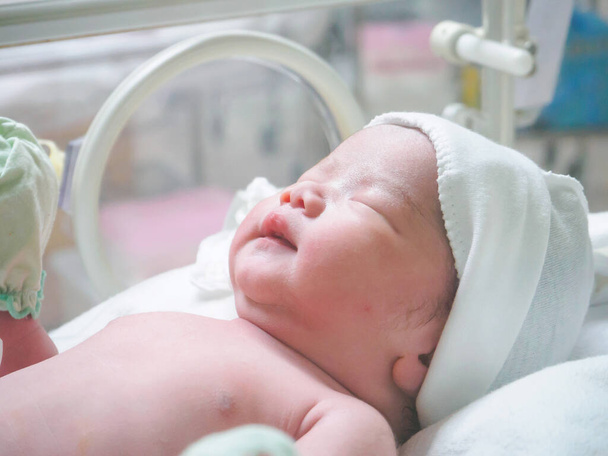 Yeni doğmuş bebek hastanedeki kuvözde uyuyor. - Fotoğraf, Görsel