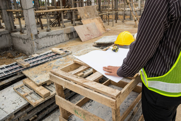 jeune homme d'affaires ingénieur ouvrier sur le chantier de construction de la maison avec un plan directeur - Photo, image