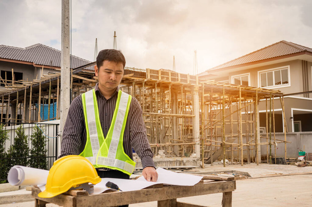 молодий бізнесмен професійний інженер-працівник на будівельному майданчику будинку з відбитками
 - Фото, зображення