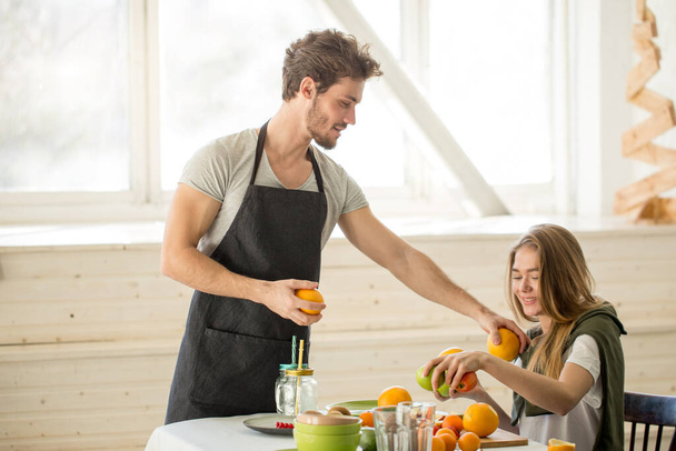 awesome man giving advice to a girl while cooking in the kitchen - Foto, Bild