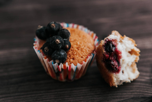 homemade muffin stuffed with black currant on a dark background - Zdjęcie, obraz