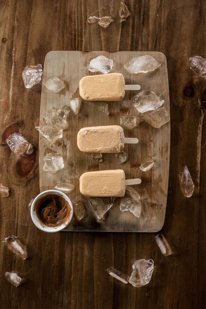 Homemade sweet milk ice cream or popsicles garnished with pieces of ice and, top view - Photo, Image