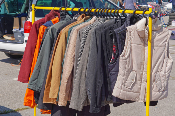 Куртки жилети і костюми, що висять на рейок для одягу блошиний ринок
 - Фото, зображення
