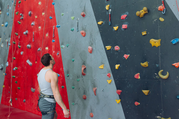 young attractive guy looking at the artificial rock wall - Photo, image