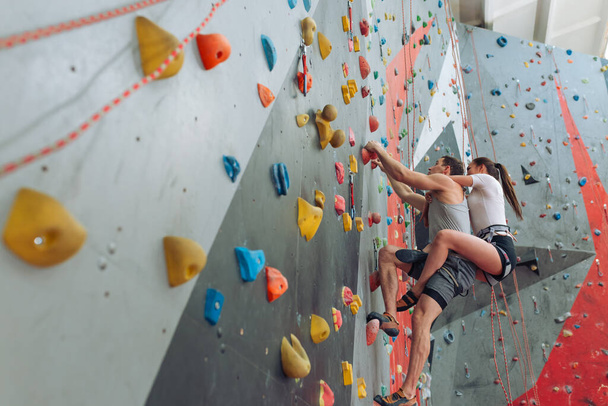 a couple wotking out in an indoor bouldering gym - Fotografie, Obrázek