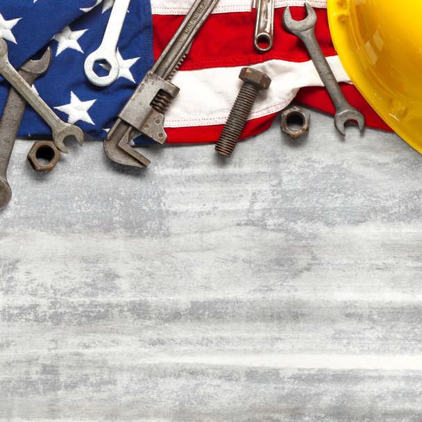 Dia de trabalho ou conceito de trabalho americano com ferramentas de construção e fabricação em patriótico EUA, EUA, bandeira americana em fundo de madeira branca
 - Foto, Imagem
