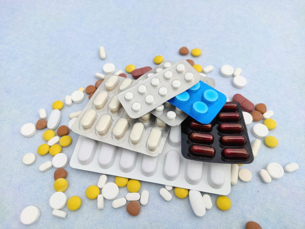 tabletki i tabletki rozłożone na niebieskim tle z miejsca na ksero i selektywną ostrość - Zdjęcie, obraz