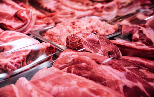 Veel rood en rauw vlees in een vleeswinkel - Foto, afbeelding