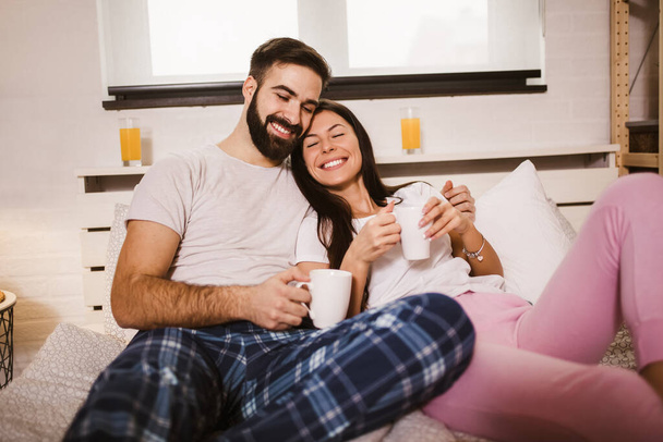 Młoda szczęśliwa para pije rano kawę w łóżku - Zdjęcie, obraz