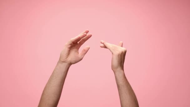 young man holding hands in the air, moving, gesturing and dancing on pink background - Footage, Video