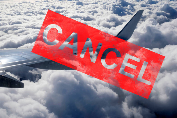 Airplane tail in the clouds with the word cancel on top. - Photo, Image