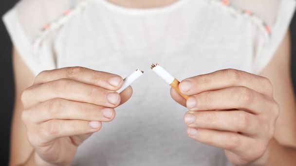 saúde conceito, não fumar, mau hábito. menina segura um cigarro quebrado em suas mãos close-up
 - Foto, Imagem