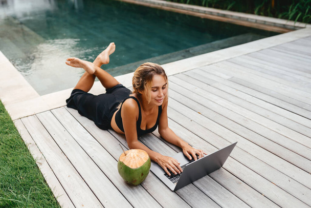 Woman freelance work typing on laptop with fresh coconut . - Foto, Bild