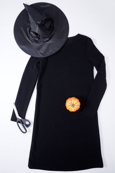 Üst görünüm siyah elbise ve sihirbaz şapkası Cadılar Bayramı veya Sonbahar arkaplanı için moda dekorasyonu - Fotoğraf, Görsel