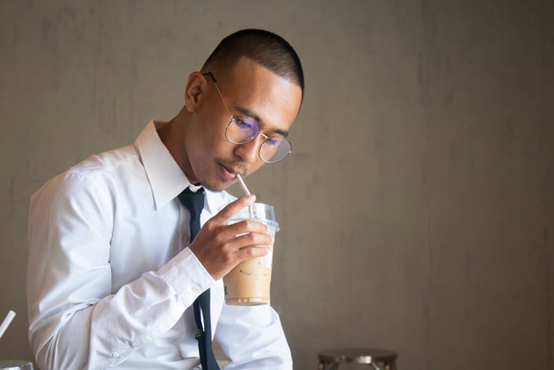 Aasialainen liikemies juo jääkahvia kahvilassa - Valokuva, kuva