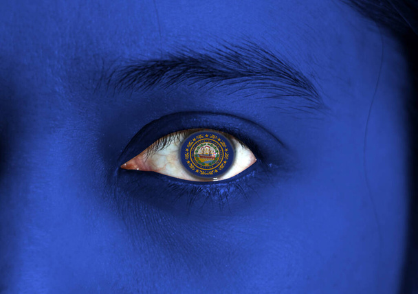 Людське обличчя зобразило прапор Нью-Гемпшира з державною печаткою в центрі ока або очного яблука. Людське око, намальоване прапором Нью - Гемпшира.. - Фото, зображення