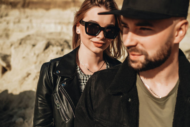 ハッピーカップルは黒革とジーンズジャケットのように服を着て楽しい時間を過ごす外の都市 - 写真・画像