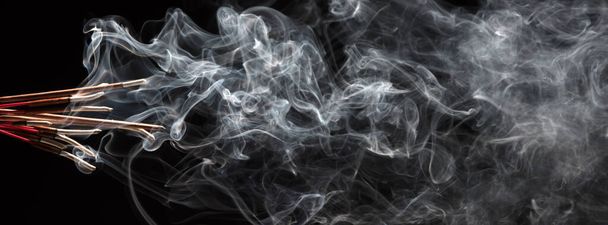 Creative illustration of incense stick aroma with smoke isolated on black background - Foto, Bild