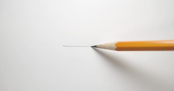 Tekenen van een rechte lijn over papier met een geel potlood. - Video