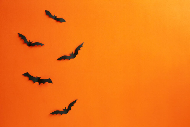 Cadılar Bayramı ve dekorasyon konsepti kağıt yarasalar kağıt turuncu arka planda uçuyor - Fotoğraf, Görsel