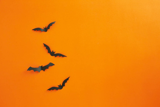 Halloween y decoración concepto murciélagos de papel volando sobre fondo de papel naranja - Foto, Imagen