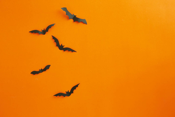Halloween és dekoráció koncepció papír denevérek repülő papír narancs háttér - Fotó, kép
