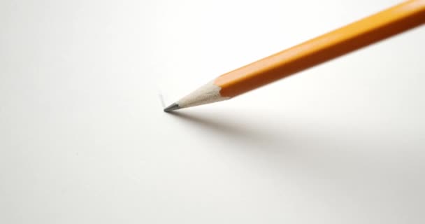 Rysunek znaku kontrolnego na białym papierze z żółtym ołówkiem szkolnym. - Materiał filmowy, wideo